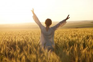 Woman with arms outstretched in a wheat field