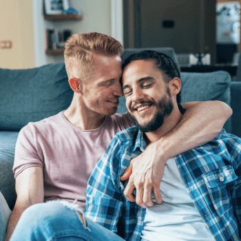 Coaching tools to break defensive habits Two men cuddling on a couch in a harmonious relationship